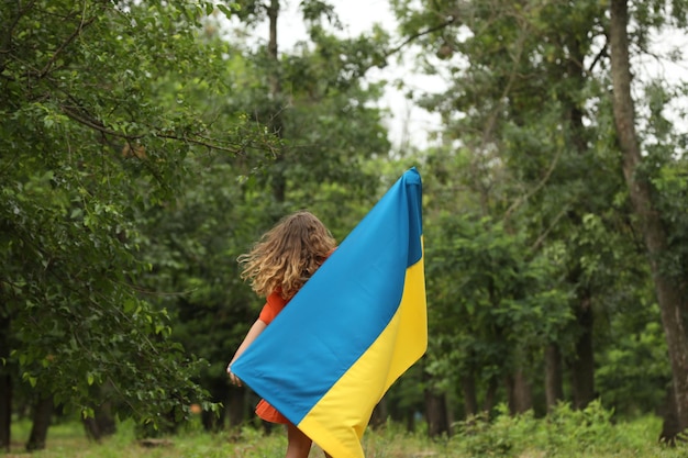 Teenager-Mädchen mit Flagge der Ukraine im Freien