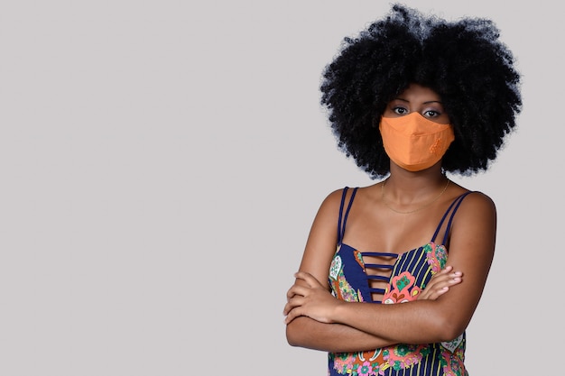 Teenager-Mädchen mit Gesichtsschutzmaske gegen Covid-19 isoliert auf grauem Hintergrund