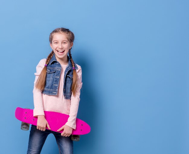 Teenager-Mädchen mit rosa Skateboard