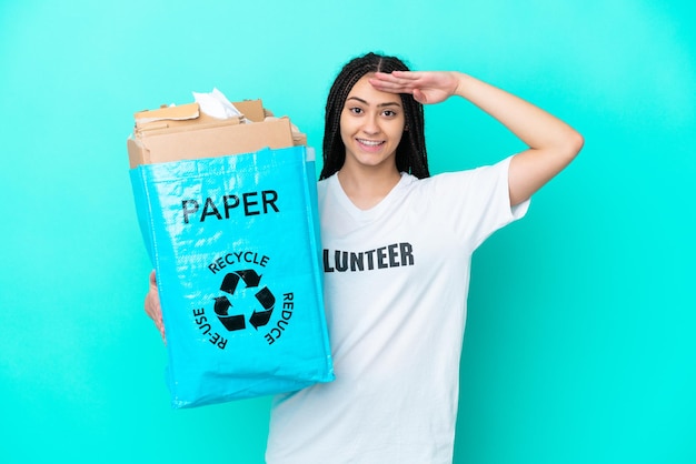 Teenager-Mädchen mit Zöpfen, die eine Tasche halten, um mit der Hand mit glücklichem Ausdruck zu grüßen