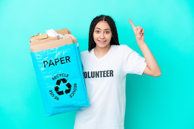 Teenager-Mädchen mit Zöpfen, die eine Tasche zum Recyceln halten und auf eine großartige Idee hinweisen