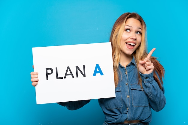 Teenager-Mädchen über isoliertem blauem Hintergrund, der ein Plakat mit der Nachricht PLAN A hält und denkt