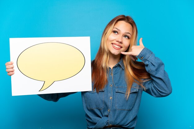 Teenager-Mädchen über lokalisiertem blauem Hintergrund, der ein Plakat mit Sprechblasen-Symbol hält und Telefongeste tut