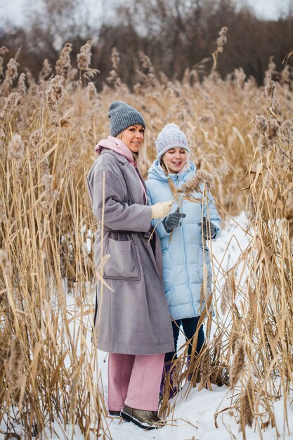 Teenager-Mädchen und ihre Mutter auf dem Feld im Winter