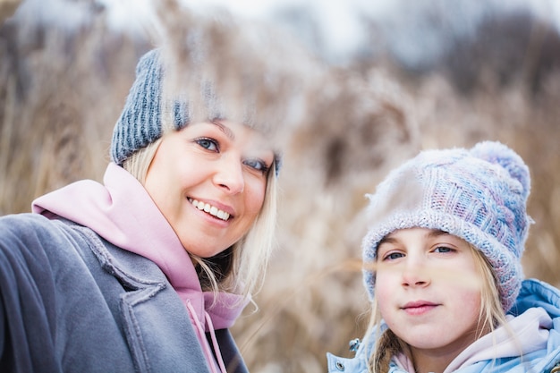 Teenager-Mädchen und ihre Mutter auf dem Feld im Winter