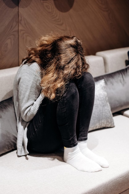 Teenager-Mädchen weint auf der Couch Pubertät und Depression