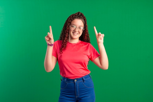 Teenager mit Brille in lustigen Posen auf einem Studiofoto mit grünem Hintergrund, ideal zum Zuschneiden