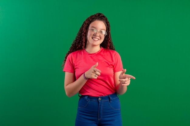 Teenager mit Brille in lustigen Posen auf einem Studiofoto mit grünem Hintergrund, ideal zum Zuschneiden