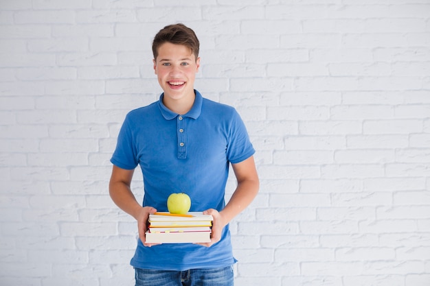 Teenager mit Büchern und Apfel