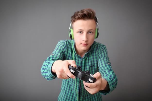 Foto teenager mit gamepad auf grau