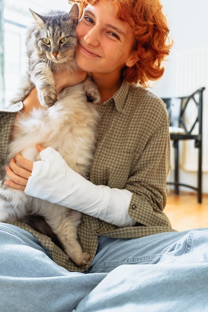 Teenager mit gebrochenem Gipsarm und Hauskatze