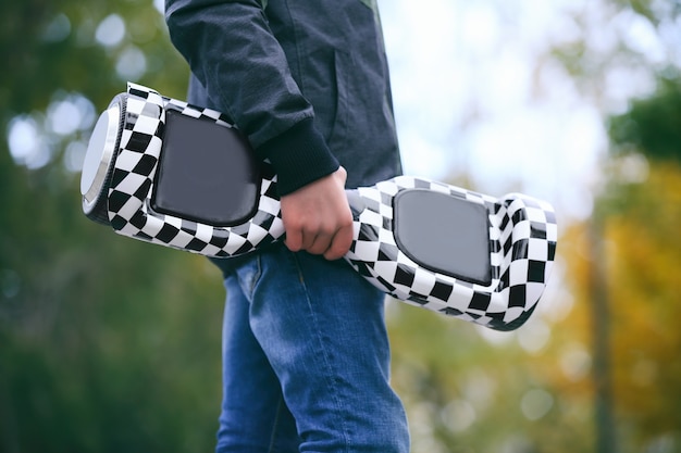 Teenager mit Gyroscooter im Park am Herbsttag