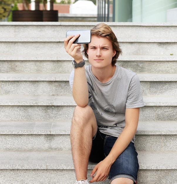 Foto teenager nutzt smartphone-selfie
