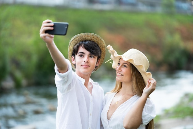 Teenager-Paar schaut aufs Telefon und macht Selfie