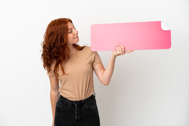 Teenager rothaarige Mädchen isoliert auf weißem Hintergrund mit einem leeren Plakat