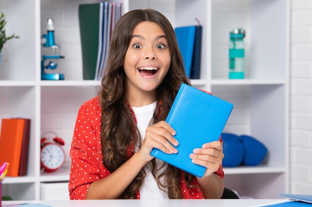 Teenager Schulmädchen halten Buch bereit zu lernen Aufgeregtes Gesicht fröhliche Emotionen von Teenager-Mädchen