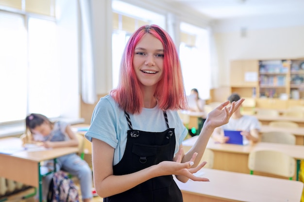 Teenager-Student antwortet im Klassenzimmer mit Studienstudenten-Hintergrund