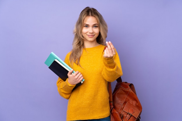 Teenager-Studentenmädchen auf lila, die Geldgeste macht