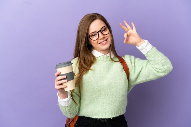 Teenager-Studentenmädchen über isoliertem lila Hintergrund, der ein OK-Zeichen mit den Fingern zeigt