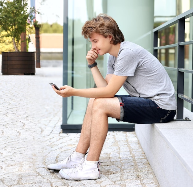 Teenager tippt SMS mit Smartphone