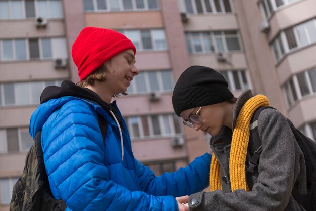 Teenager-Typ und ein Mädchen auf einem Spaziergang in der Stadt im Frühling in hellen Kleidern