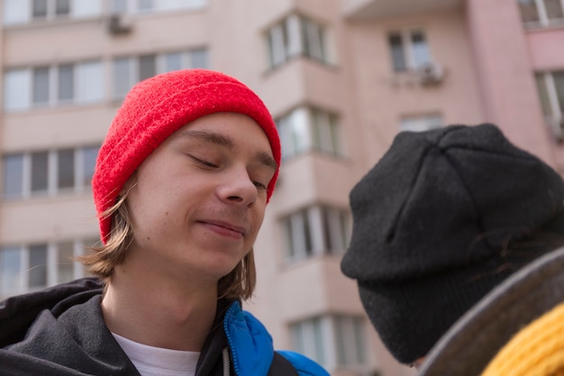 Teenager-Typ und ein Mädchen auf einem Spaziergang in der Stadt im Frühling in hellen Kleidern