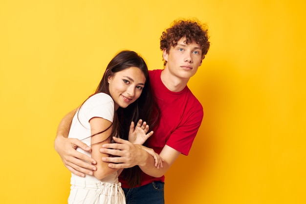 Teenager umarmen Possen gelben Hintergrund unverändert