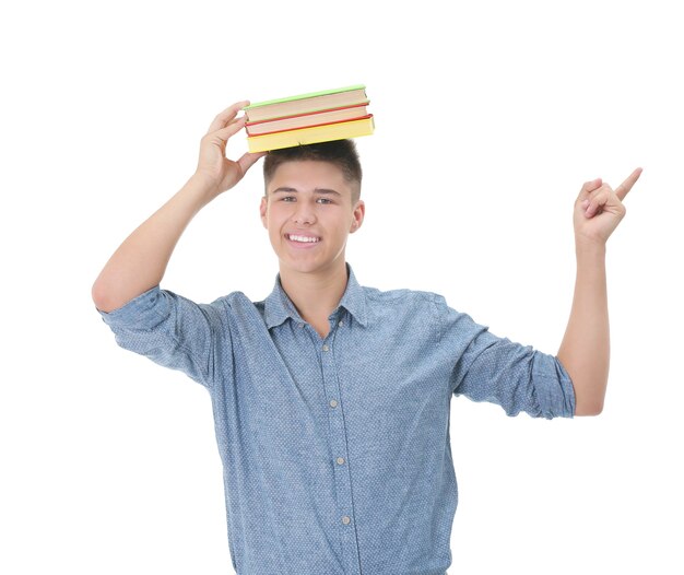 Teenagerjunge mit Büchern auf weißer Oberfläche