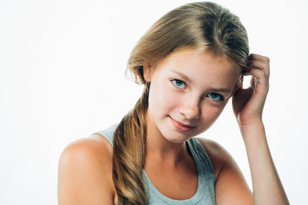 Teenagermädchen berührt sich das Haar. Porträt der Frau weiblich mit Sommersprossengesicht. Studioaufnahme.