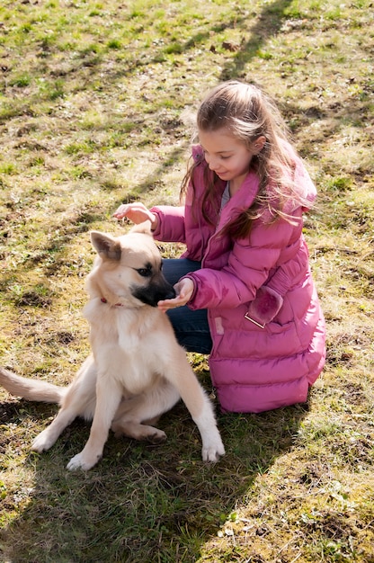 Teeneger niña jugando con su perro al aire libre