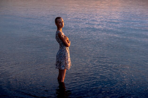 Teenie-Mädchen im Kleid am Meer versucht, ins Wasser zu gelangen