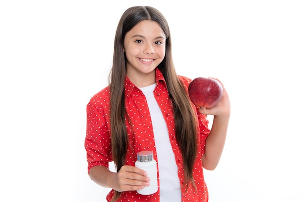 Teenie-Mädchen mit Apfel und natürlichen Lebensmittelzusatzstoffen oder Vitaminpillen gesunder Lebensstil Präsentieren Kapselform Tablette für Kinder Porträt von glücklich lächelnden Teenager-Mädchen, isoliert auf weiss