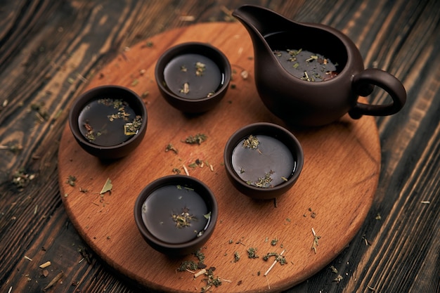 Teeservice und Teeblätter auf Holzuntergrund