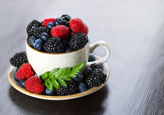 Teetasse mit Beeren Nahaufnahme auf einem Holztisch