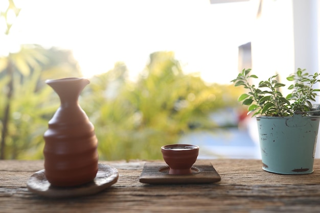 Teetasse und Teekanne aus braunem Steingut auf Holztisch