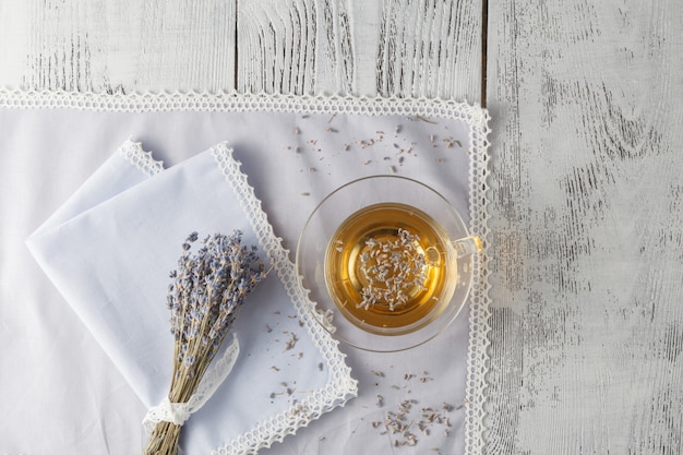 Teetasse und trockene Lavendelblumen auf Tisch.