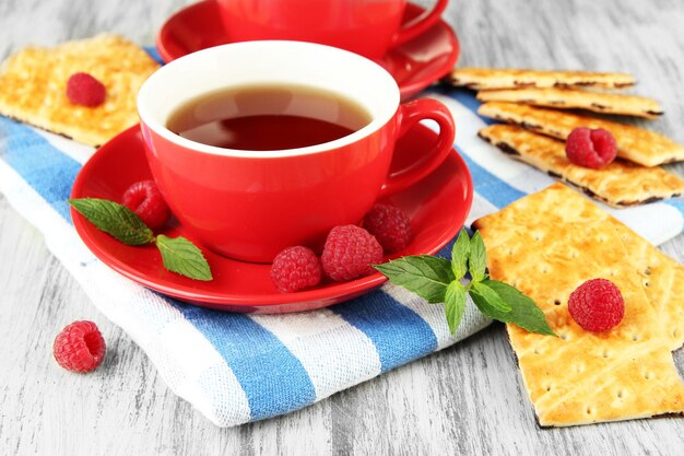 Teetassen mit Kekse und Himbeeren auf dem Tisch in Nahaufnahme