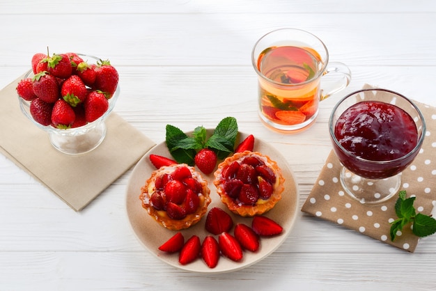 Teetrinken mit Törtchen und Kuchen mit Erdbeeren