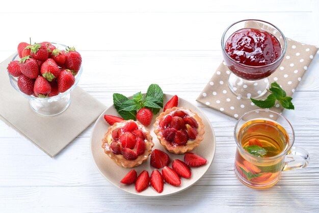 Teetrinken mit Törtchen und Kuchen mit Erdbeeren