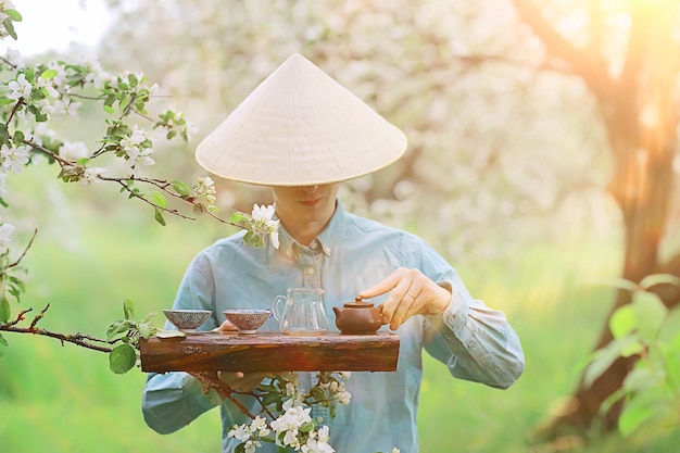 Teezeremonie, asiatischer Teemeister bereitet frischen grünen Frühlingstee im Garten zu