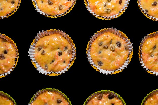 Teig für Muffins in Papierformen Der Prozess der Herstellung von hausgemachten Rosinenkuchen