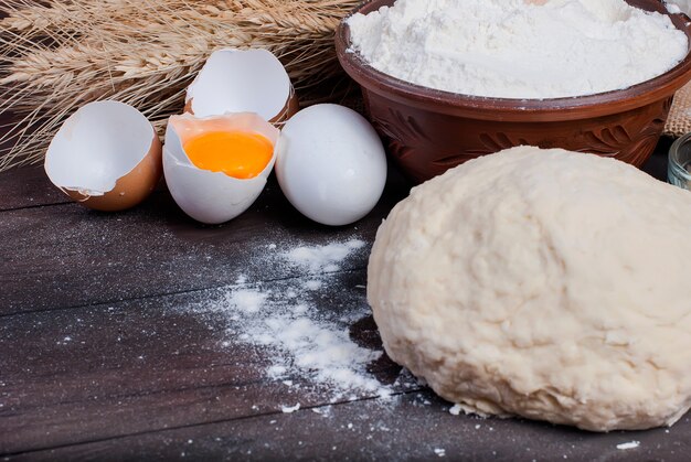 Teig und Zutaten für das Backen auf dem alten Holztisch