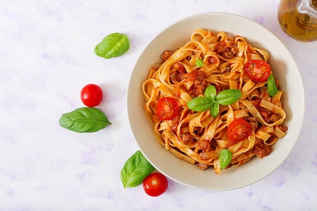 Teigwaren Fettuccine Bolognese mit Tomatensauce in der weißen Schüssel.