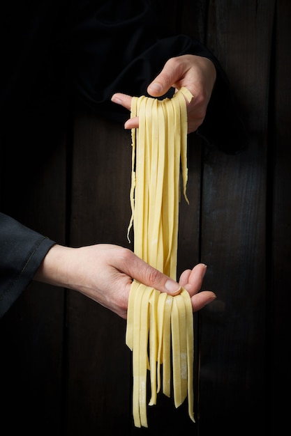 Teigwaren in den Händen. Hausgemachte Pasta.