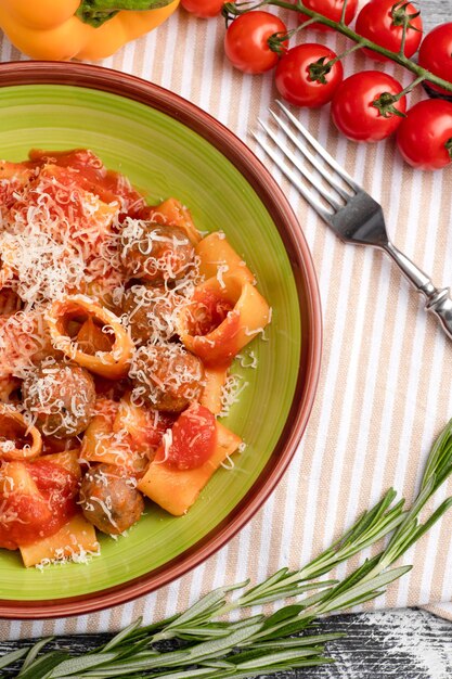 Teigwaren mit Fleischbällchen Teigwaren mit Tomaten und Fleisch auf einer Draufsicht des weißen hölzernen Hintergrundes Beschneidungspfad eingeschlossen