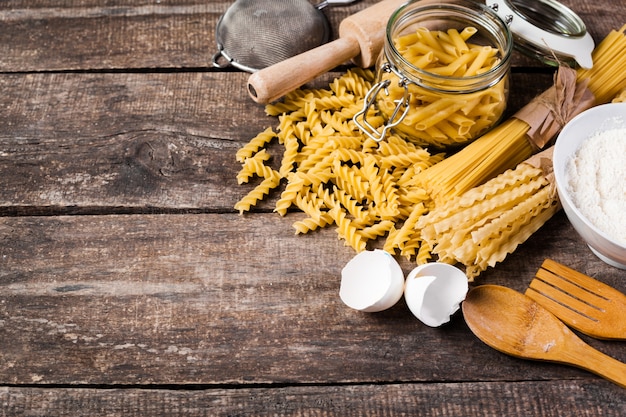 Teigwarenspaghettis mit Mehl, Ei auf altem Holztisch