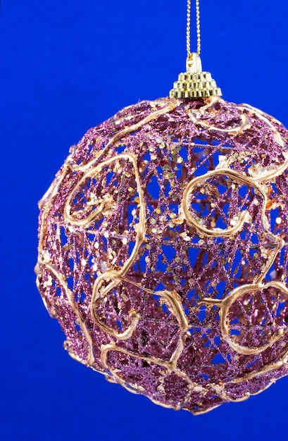 Teil der festlichen Weihnachtsrosa hängenden Ball auf blauem Hintergrund (riffling Karton Textur bewahren)