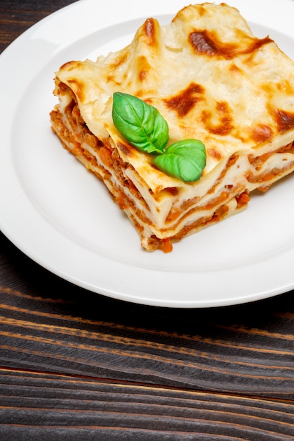 Teil der leckeren Lasagne auf hölzernem Hintergrund