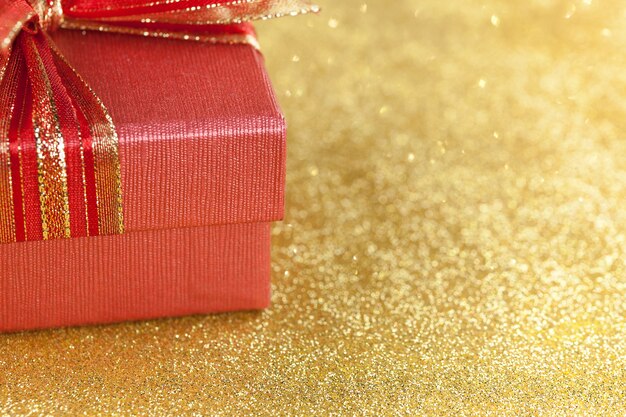 Teil der roten Geschenkbox auf Funkelngoldhintergrund