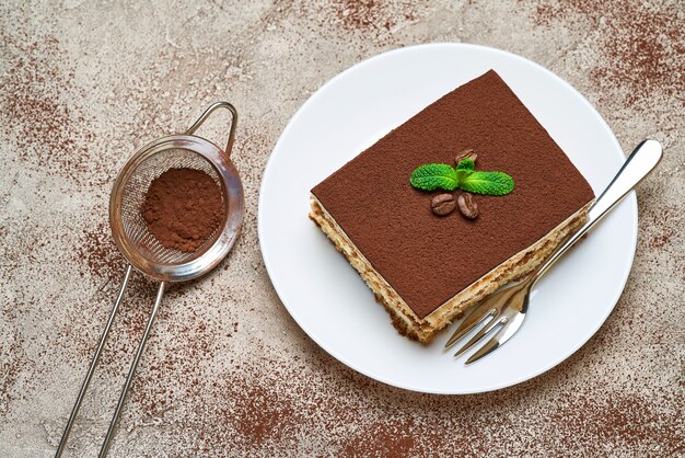 Teil des traditionellen italienischen Tiramisu-Nachtischs auf grauem Betontisch